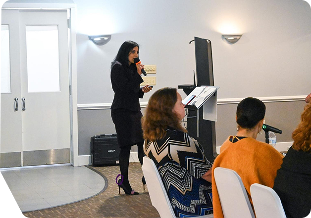 Angel Mary speaking at a leadership workshop with an audience seated in front of her