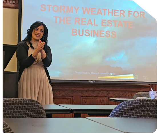 Angel Mary motivational speaker presenting in front of a slide titled Stormy Weather for the Real Estate Business